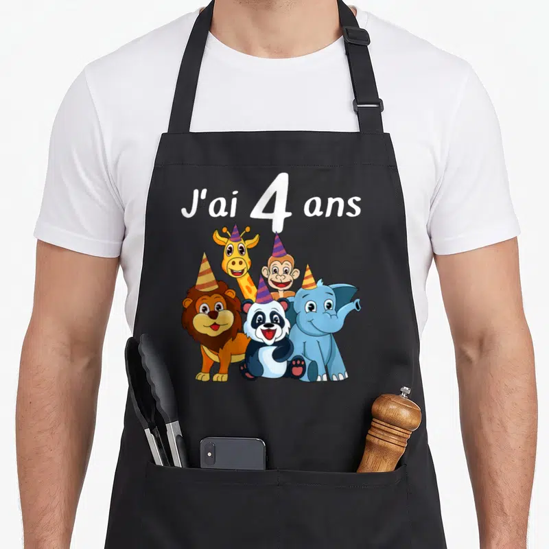Tablier de cuisine noir avec un lion, un panda, une girafe, un singe et un éléphant portant des bonnets de fête colorés.