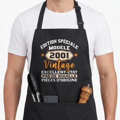 Tablier de cuisine noir avec inscription édition spéciale 2001 vintage et étoiles oranges.