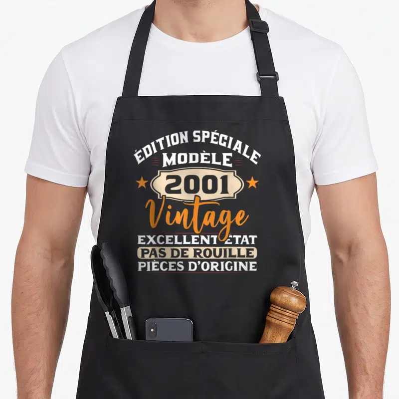 Tablier de cuisine noir avec inscription édition spéciale 2001 vintage et étoiles oranges.
