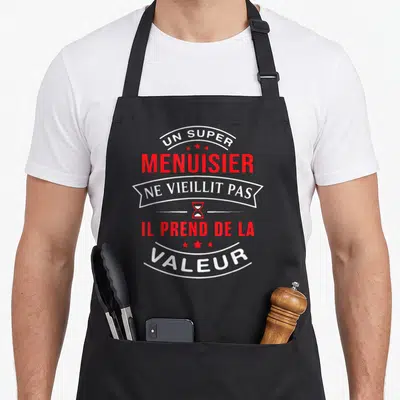 Tablier de cuisine noir avec inscription blanche et rouge Un Super Menuisier Ne Vieillit Pas Il Prend De La Valeur et un sablier.