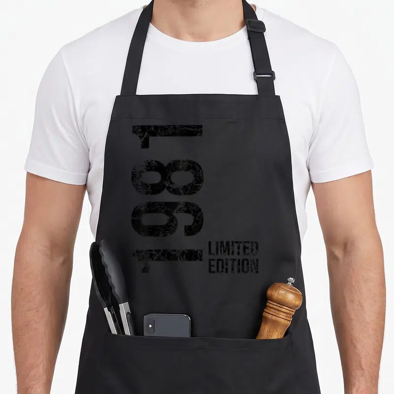 Tablier de cuisine noir avec l'année 1981 imprimée verticalement en gros chiffres noirs et l'inscription Limited Edition en bas à droite.