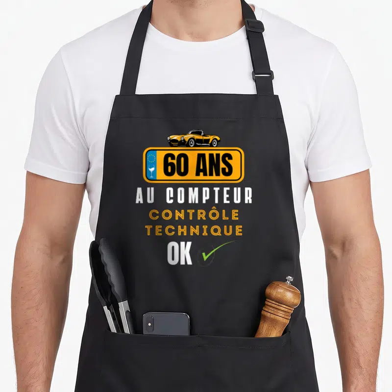 Tablier de cuisine noir avec plaque orange 60 ans au compteur contrôle technique ok et voiture jaune.