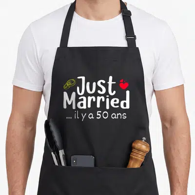 Tablier de cuisine noir avec l'inscription Just Married il y a 50 ans et des anneaux dorés.