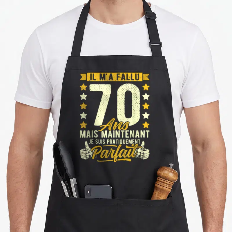 Tablier de cuisine noir avec inscription Il m'a fallu 70 ans mais maintenant je suis pratiquement parfait entouré d'étoiles et de mains.