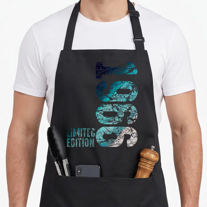 Tablier de cuisine noir avec l'inscription 60 ans limited edition en bleu et blanc texturé.