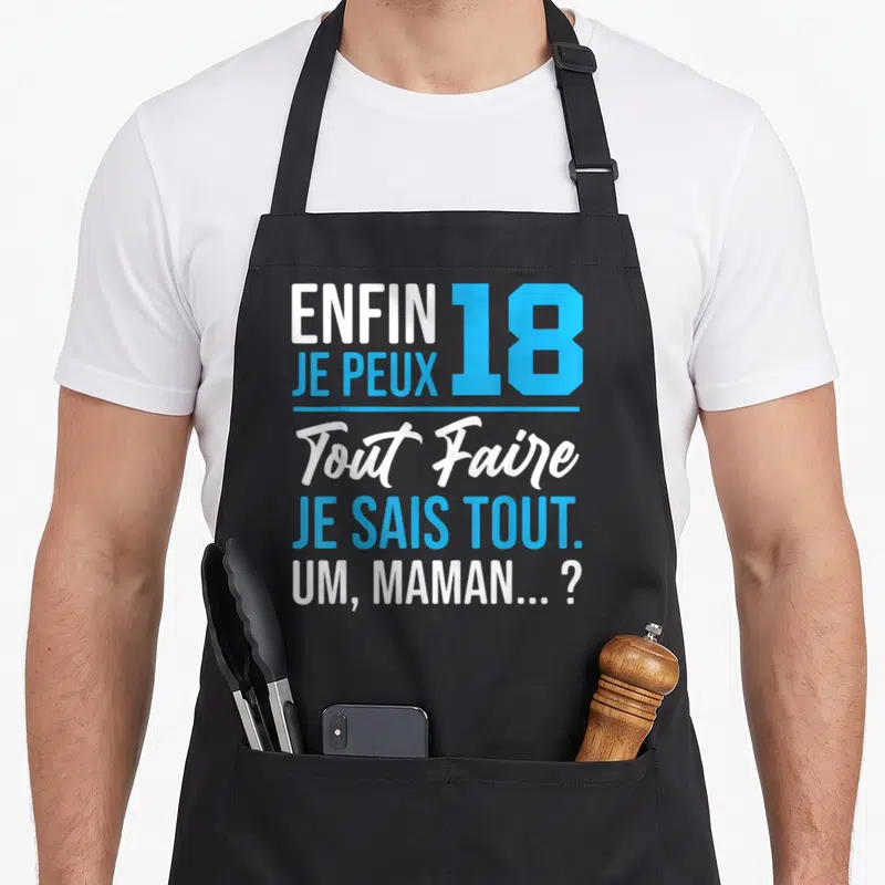 Tablier de cuisine noir avec le texte enfin 18 je peux tout faire je sais tout um maman en bleu et blanc.