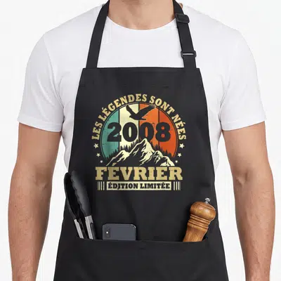 Tablier de cuisine noir avec motif circulaire vintage affichant un aigle, des montagnes et le texte Les légendes sont nées en février 2008.