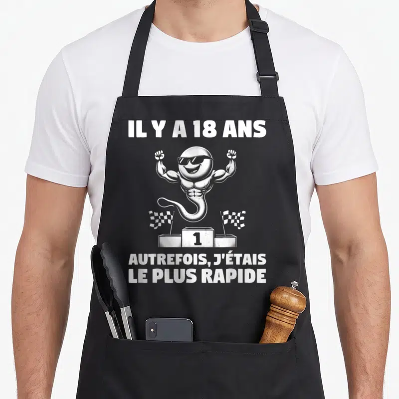 Tablier de cuisine noir avec une graine musclée aux lunettes de soleil sur un podium numéroté 1 et des drapeaux à damier.
