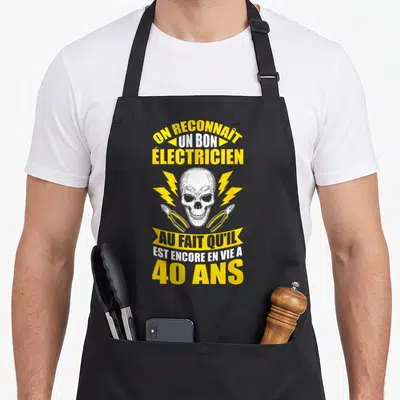 Tablier de cuisine noir avec crâne, foudres jaunes et texte sur les 40 ans d'électricien