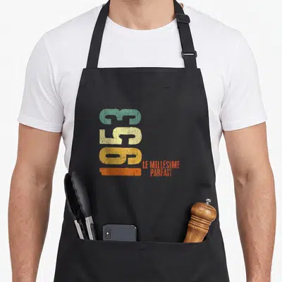 Tablier de cuisine noir avec le chiffre 72 coloré et l'inscription Le millésime parfait en typographie vintage.