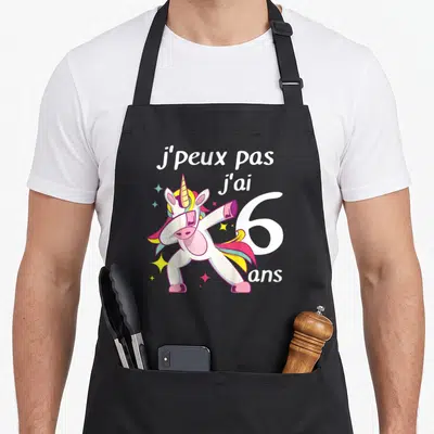 Tablier de cuisine noir avec licorne colorée effectuant un mouvement dab et le chiffre six blanc.