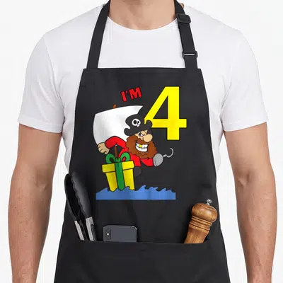 Tablier de cuisine noir avec illustration d'un pirate barbu tenant un cadeau jaune près du chiffre 4 jaune et du texte I'M en rouge.