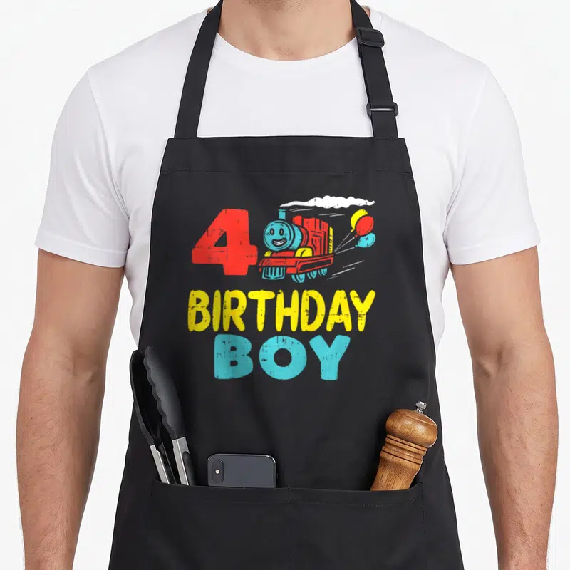 Tablier de cuisine noir avec un train bleu, le chiffre 4 rouge et des ballons colorés.