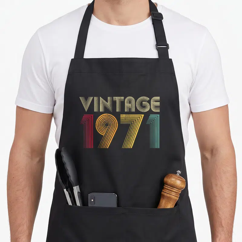 Tablier de cuisine noir avec motif vintage 1971 en lettres colorées et rayures rétro des années soixante-dix.