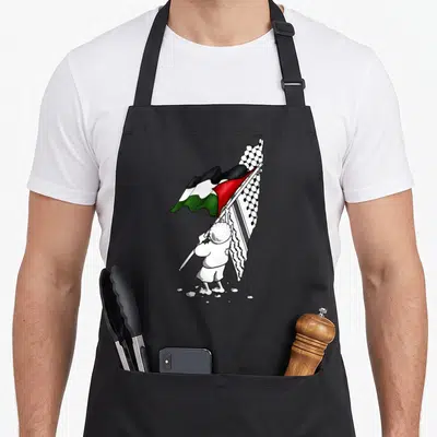 Tablier de cuisine noir avec enfant portant drapeau palestinien et keffieh, texte Free Gaza imprimé.