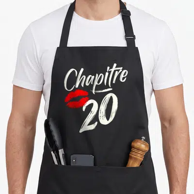 Tablier de cuisine noir avec linscription Chapit 20 et une trace de rouge à lèvres rouge vif au centre du motif.