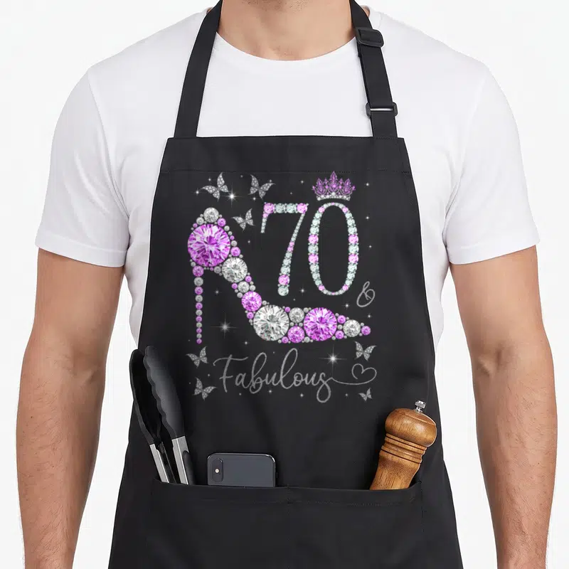 Tablier de cuisine noir avec un talon haut en diamants roses et le texte 70 Fabulous