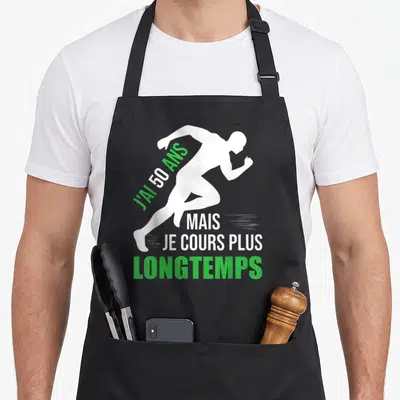 Tablier de cuisine noir avec silhouette de coureur blanc et texte vert J'ai 50 ans mais je cours plus longtemps