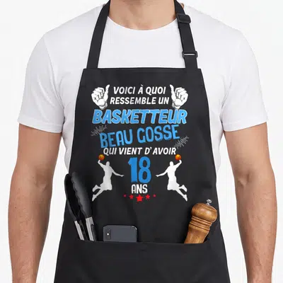 Tablier de cuisine noir avec illustration de basketteurs et texte bleu célébrant les 18 ans.