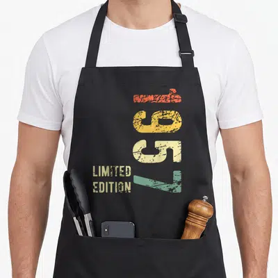 Tablier de cuisine noir avec chiffres 69 verticaux colorés et texte limited edition en style rétro délavé.