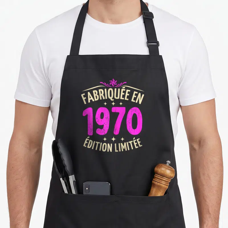 Tablier de cuisine noir avec inscription Fabriquée en 1970 « Édition Limitée » en rose et doré.
