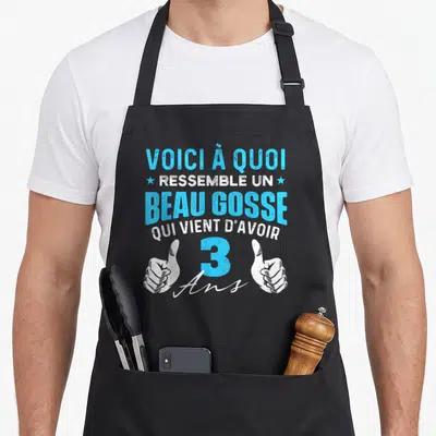 Tablier de cuisine noir avec inscription Voici à quoi ressemble un beau gosse qui vient d'avoir 3 ans et deux mains faisant des pouces levés.