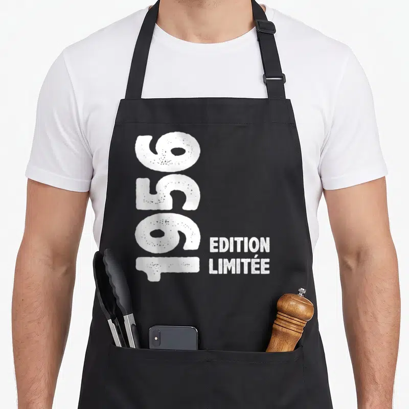 Tablier de cuisine noir avec l'inscription 70 ans 1956 Edition Limitée en blanc vertical et style grunge.