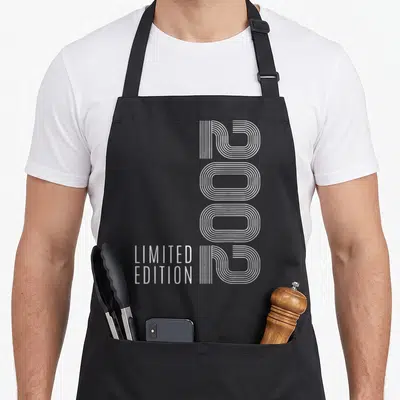 Tablier de cuisine noir avec le chiffre 2002 en lignes blanches verticales et Limited Edition en bas à gauche.