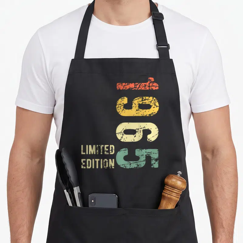 Tablier de cuisine noir avec chiffres 60 colorés verticalement et texte Limited Edition en style rétro délavé.