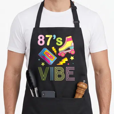 Tablier de cuisine noir avec illustration rétro 87s Ambiance cassette et patins roses jaunes et bleus.