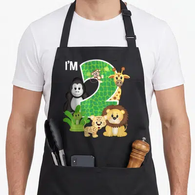 Tablier de cuisine noir avec un grand chiffre 2 vert entouré d'animaux de zoo comme un lion, une girafe et un gorille.
