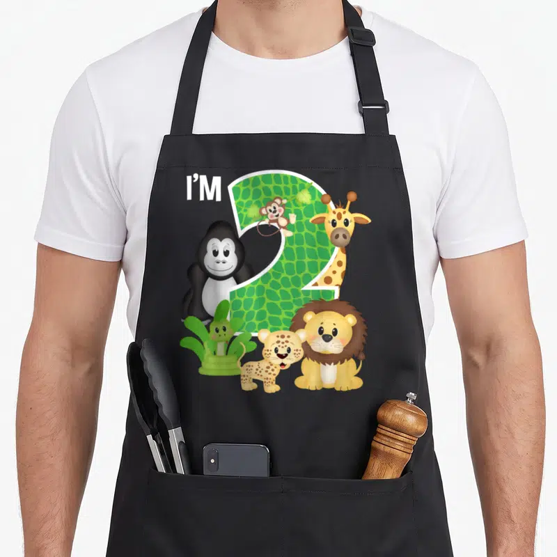 Tablier de cuisine noir avec un grand chiffre 2 vert entouré d'animaux de zoo comme un lion, une girafe et un gorille.
