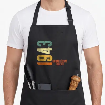Tablier de cuisine noir avec chiffres 82 43 63 vert jaune orange et texte Un millésime parfait en orange sur fond uni.