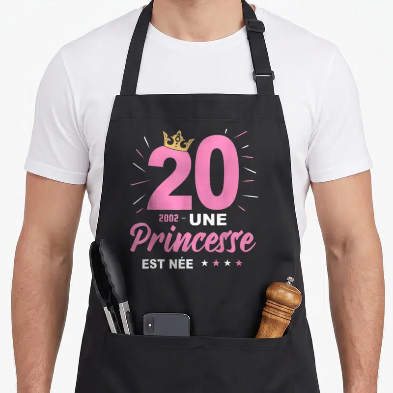 Tablier de cuisine noir avec inscription Une Princesse Est Née 2002 et couronne dorée sur le chiffre vingt.