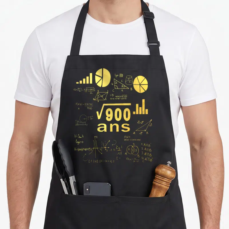 Tablier de cuisine noir avec une illustration dorée représentant des équations et la mention 900 ans.