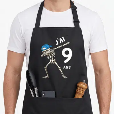 Tablier de cuisine noir avec un squelette effectuant le dab et portant une casquette bleue à l'envers.