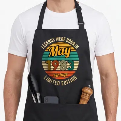 Tablier de cuisine noir avec motif circulaire retro affichant May 1983 et les mots Legends Were Born In Limited Edition Vintage.