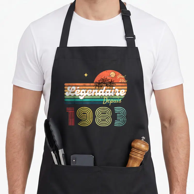 Tablier de cuisine noir avec illustration rétro Légendaire Depuis 1983 et soleil orange