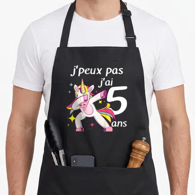 Tablier de cuisine noir avec une licorne rose effectuant un dab et l'inscription j'peux pas j'ai 5 ans.