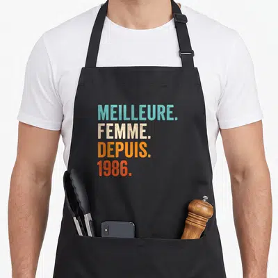 Tablier de cuisine noir avec inscription Meilleure Femme Depuis 1986 en lettres colorées style vintage.