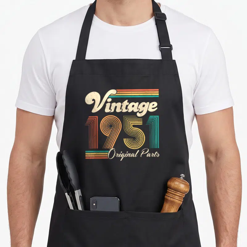 Tablier de cuisine noir avec motif vintage 1951 Original Parts en couleurs pastels et lettrage rétro.