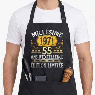 Tablier de cuisine noir avec inscription Millésime 1971 55 ans d'excellence en typographie vintage dorée et blanche.