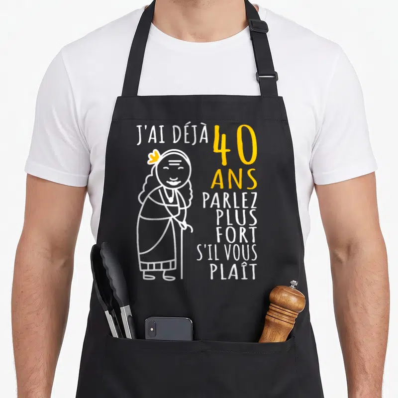 Tablier de cuisine noir avec une illustration d'une femme âgée et le texte J'ai déjà 40 ans parlez plus fort s'il vous plaît.