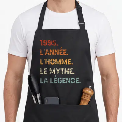 Tablier de cuisine noir avec inscription colorée 1995 lannée lhomme le mythe la légende typographie vintage.