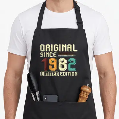 Tablier de cuisine noir avec inscription vintage Original Since 1982 Limited Edition en lettres multicolores.
