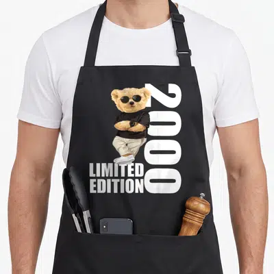 Tablier de cuisine noir avec ours portant des lunettes noires, chemise noire et texte Limited Edition 2000 en blanc.