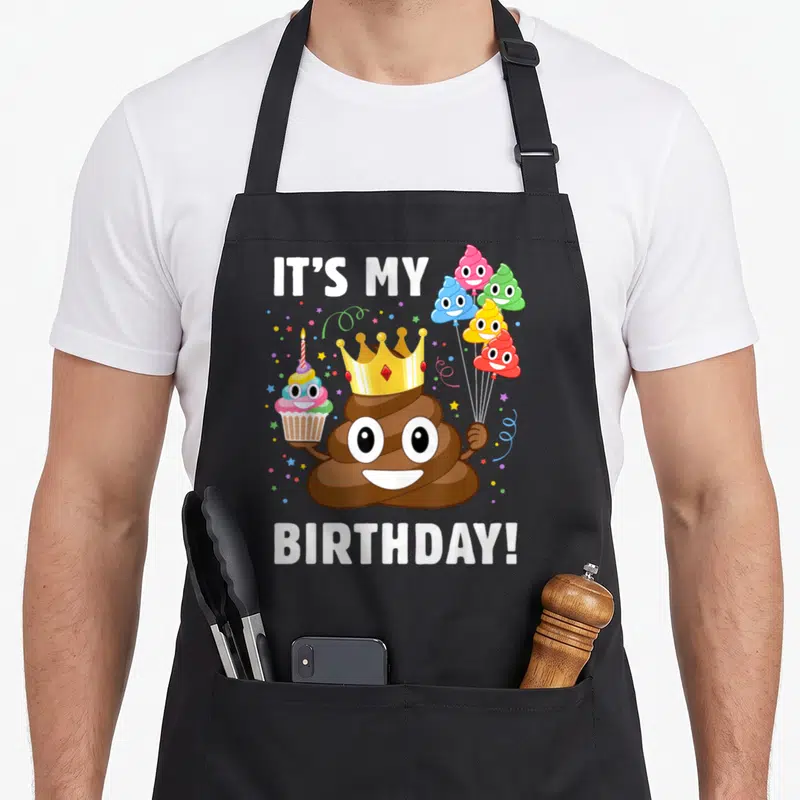 Tablier de cuisine noir avec illustration d'un personnage marron souriant portant une couronne dorée et tenant des ballons festifs.