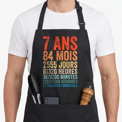 Tablier de cuisine noir avec typographie colorée indiquant sept ans et durées en mois jours heures minutes secondes.