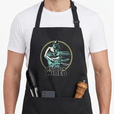 Tablier de cuisine noir avec une illustration circulaire de Jeff Beck Wired en turquoise et texte blanc.