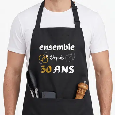 Tablier de cuisine noir avec inscription ensemble depuis 30 ans, deux anneaux dorés et un cœur blanc stylisé.